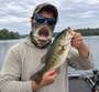 Angler wearing a Hydrave bass face gaiter while holding a bass